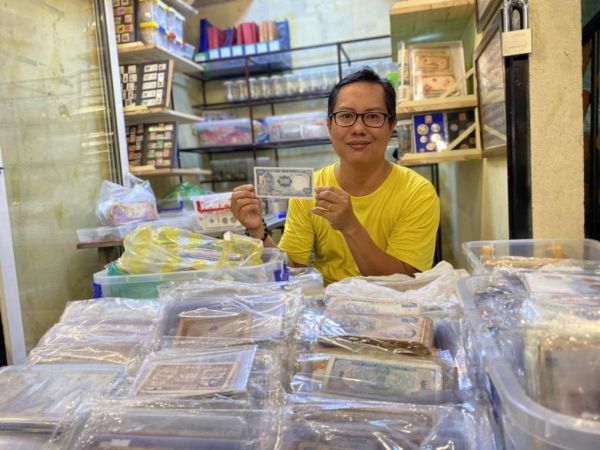 Anh Lê Nguyễn Tuấn Anh thu mua tiền rách bên cạnh việc bán tiền xưa ở quận Bình Thạnh, TP HCM, tháng 6/2023. Ảnh: Ngọc Ngân